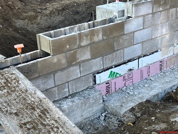 Moisture barrier and insulation on concrete masonry unit (CMU) foundation wall